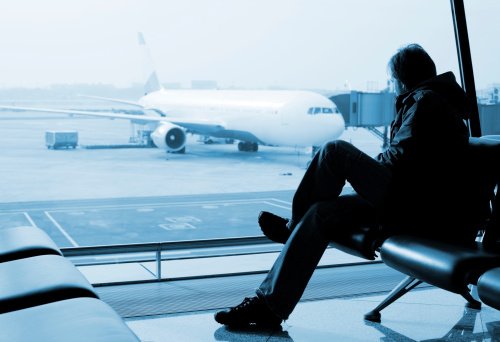 man sitting and watching airplane
